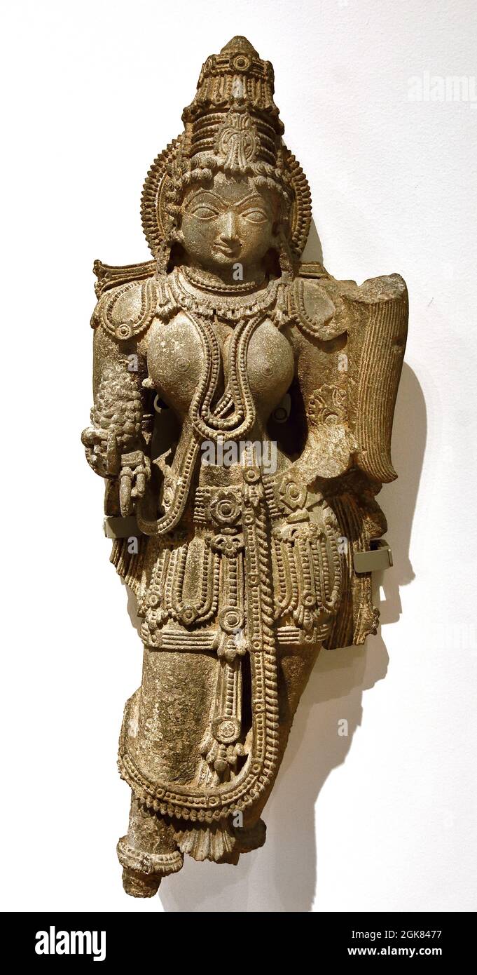 Himmlische Schönheit, 1100 - 1200 Karnataka Indien, Schiefer, 83,0 cm × 33,0 cm × 17,0 cm, Stil, Hoysala, ( Statue eines himmlischen Dieners, aus einer Tempelnische entnommen. In der rechten Hand hält die Frau eine Frucht und in der linken (abgerissenen) einen Fliegenpinsel. ) Stockfoto