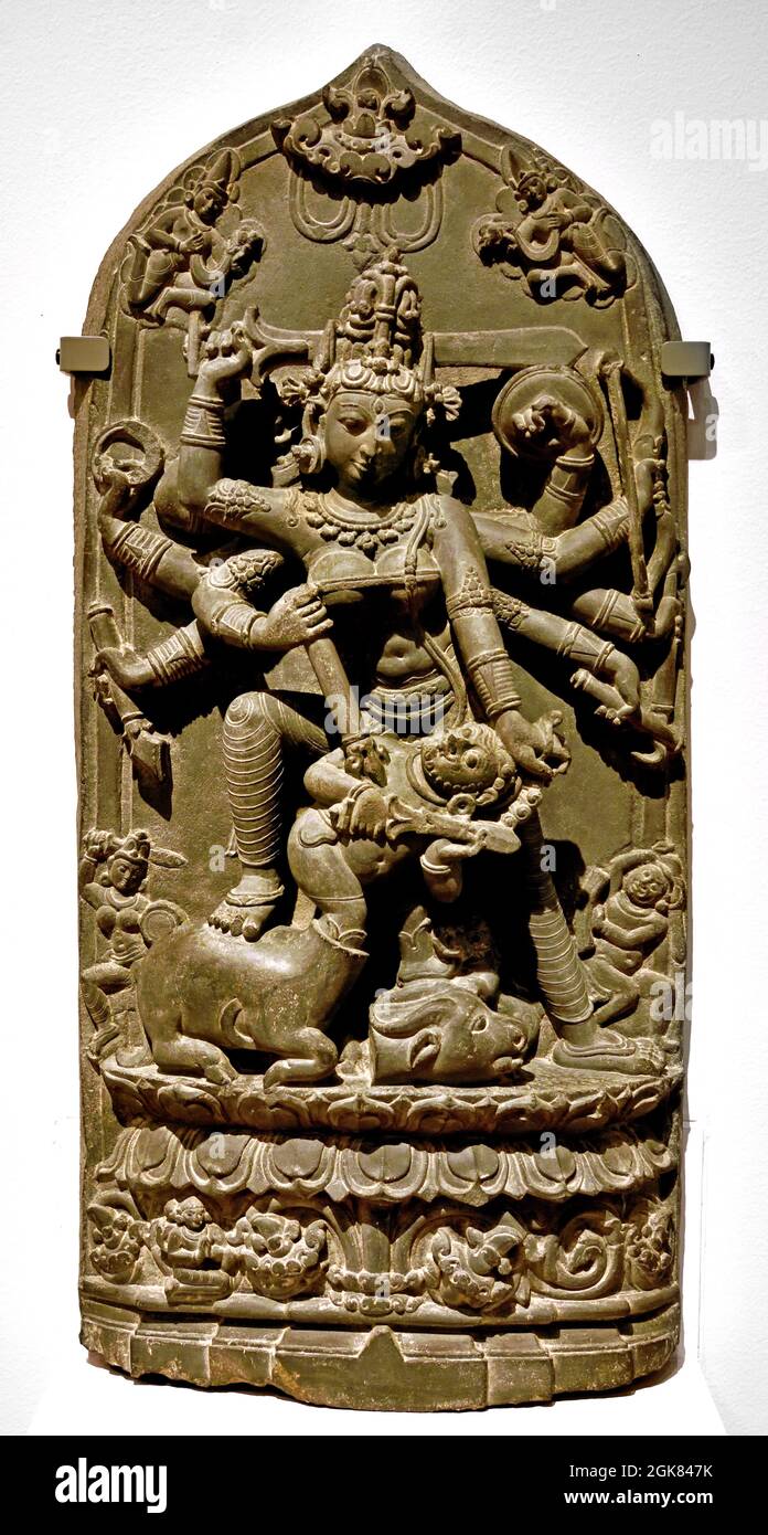 Durga Killing the Buffalo Demon, 1000 - 1100 Stone, 87,5cm × 37.0cm × 12cm Bangladesch Westbengalen Kampf zwischen der Hindu-Göttin Durga und dem Dämon wird in mehreren Sanskrit-Texten beschrieben, der Dämon könnte seine Form ändern. Er erschien zuerst als Büffel und wurde von Durga enthauptet, sein abgetrennter Kopf liegt auf dem Boden. Er erschien dann in der Gestalt eines Menschen und wurde erneut von der Göttin getötet, diesmal mit einem Dreizack. Bangladesch Westbengalen Stockfoto