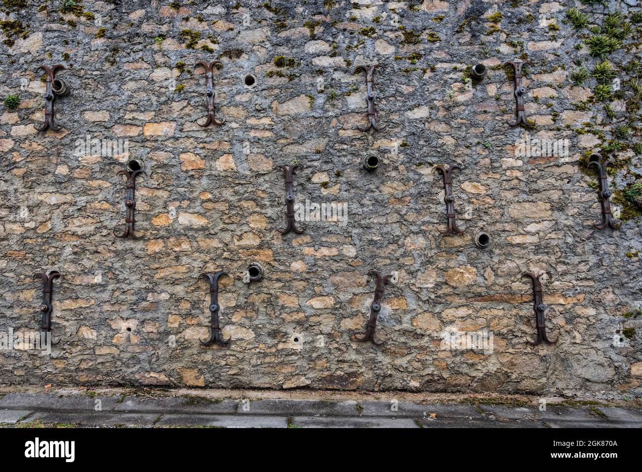 Mehrere Eisenhaltestreifen in der Wand unter der Kirche Saint Michel Archange, Fleurat, Creuse (23), Frankreich. Stockfoto