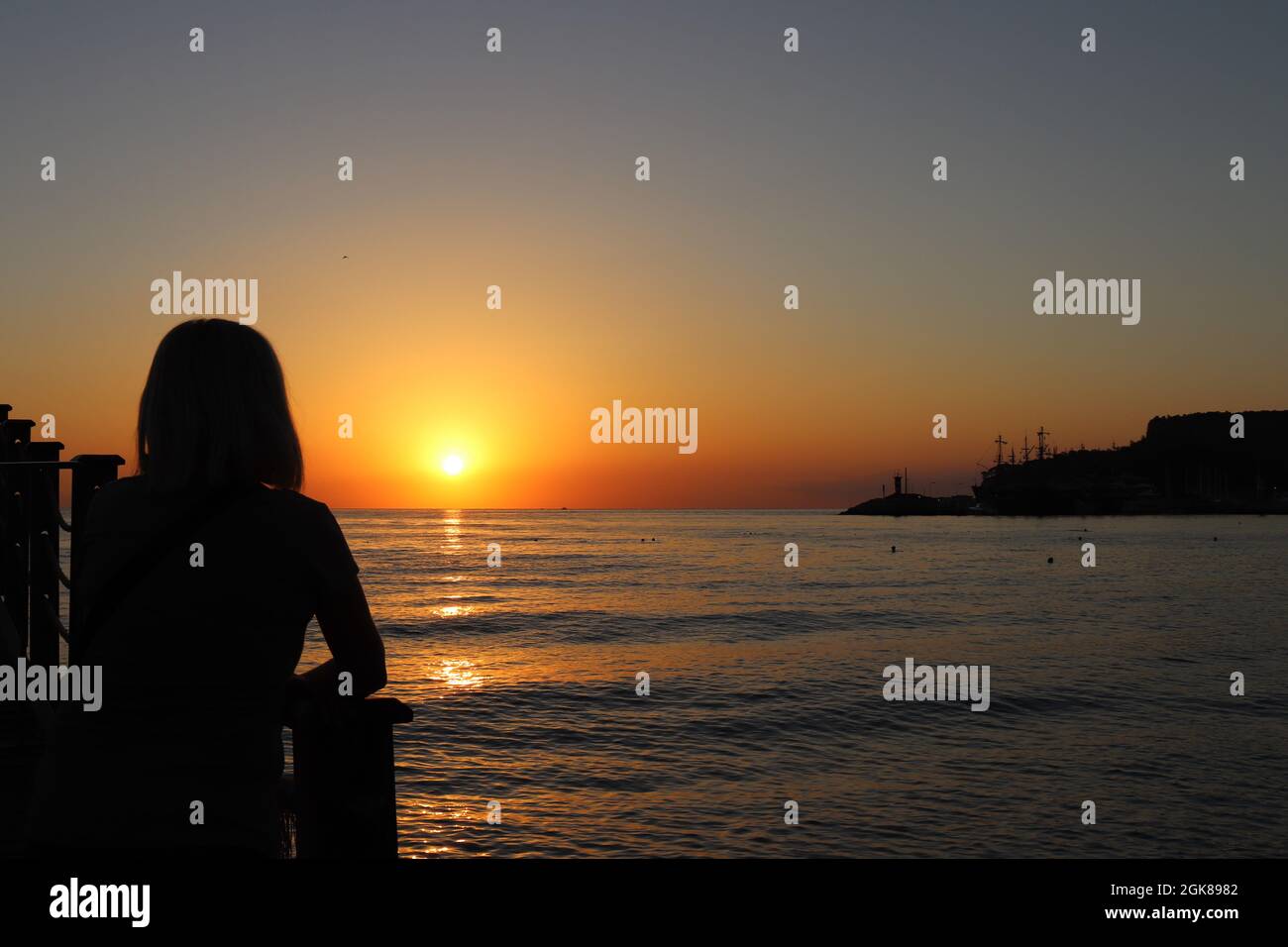 Silhouetten von Menschen und Sonnenaufgang entlang der Küste Stockfoto