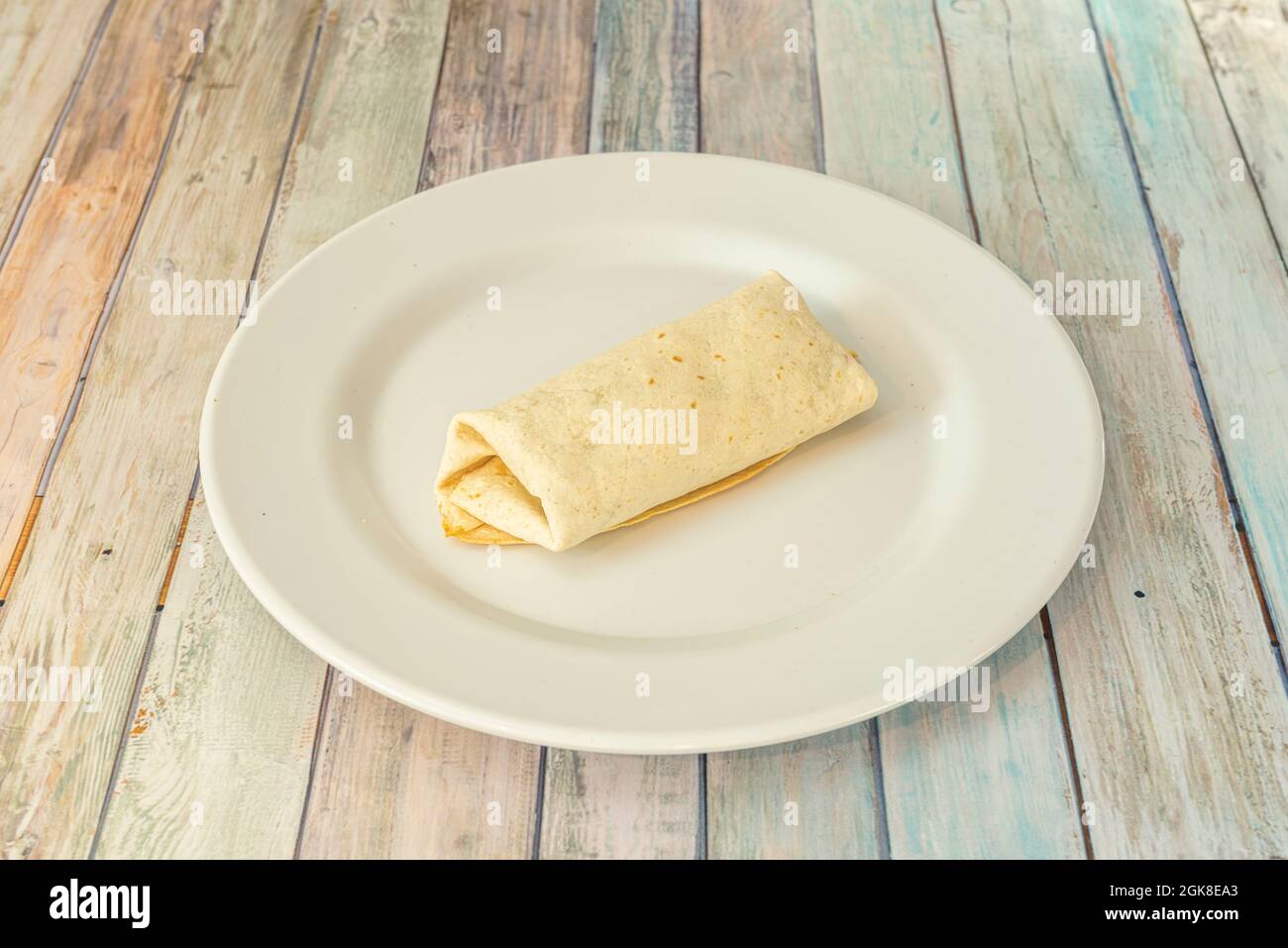 Einfacher geschlossener Burrito von Tortilla, gefüllt mit Weizen von dem, was Sie sich vorstellen möchten. Stockfoto