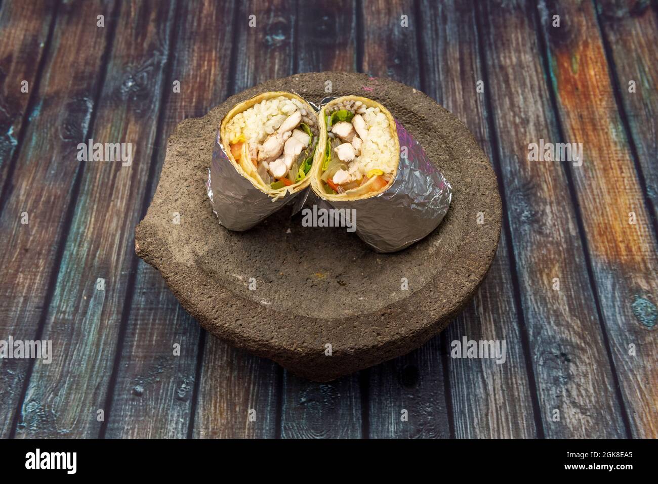 Hähnchen Fajita Burrito In Folienverpackung Über Dem Mexikanischen Vulkangestein Molcajete Stockfoto