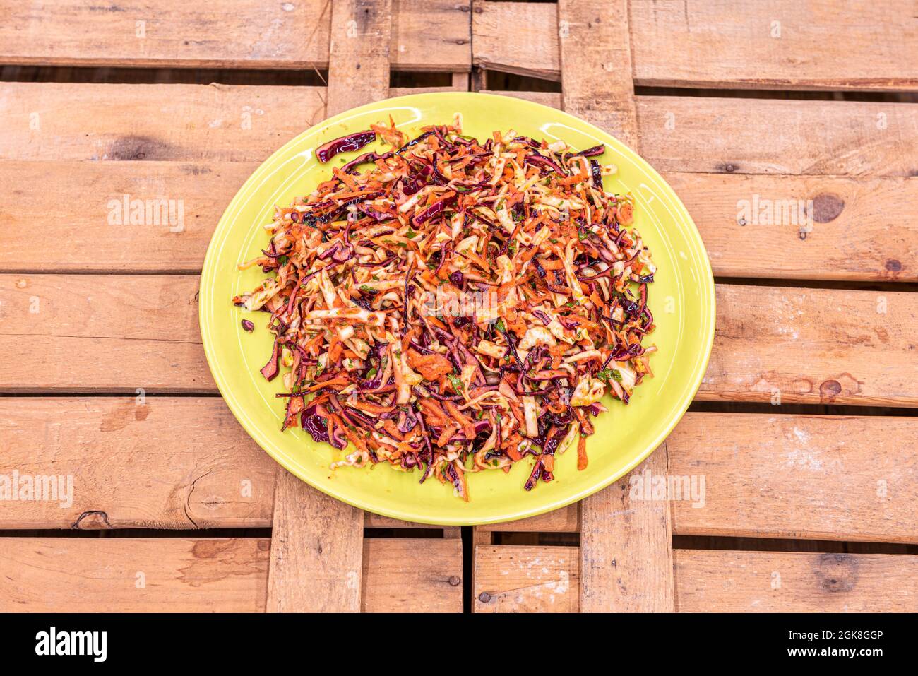 Gemüsesalat mit violettem und grünem Grünkohl, Karotten und Paprika und scharfer Sauce Stockfoto