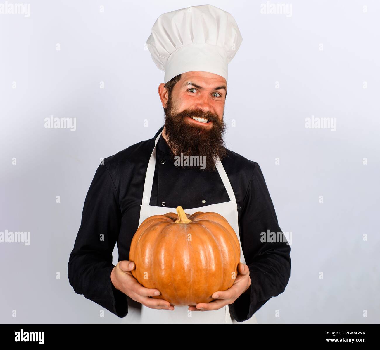 Männlicher Koch mit Kürbis. Herbstgemüse. Kürbis für Halloween. Diät-Essen. Gesunde vegetarische Ernährung. Stockfoto