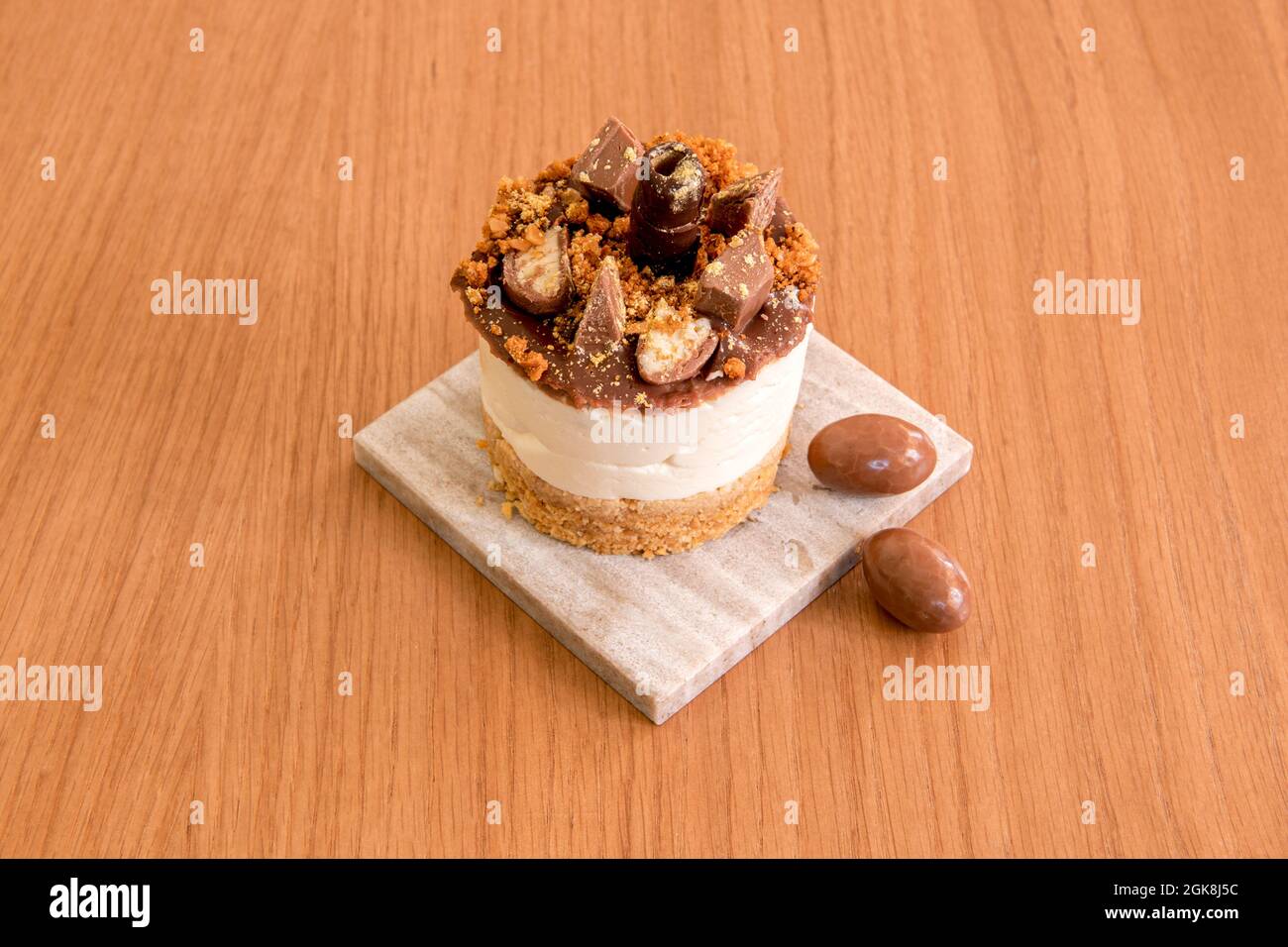 Mini-Schokoladen-Käsekuchen mit Prise verschiedener Schokoladensorten auf einem grauen Marmorplatte Stockfoto