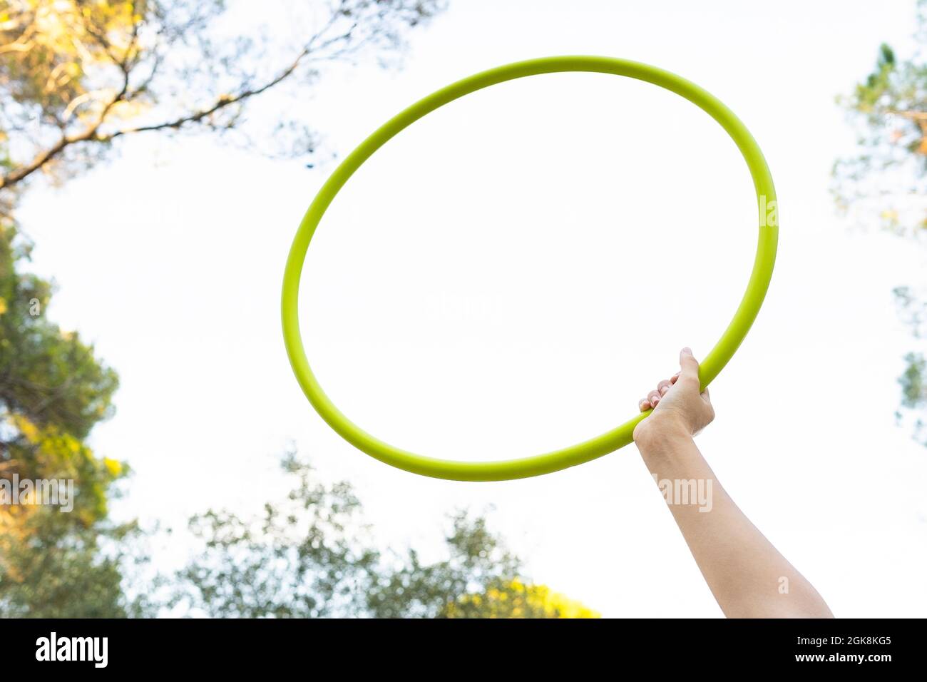 Von unten der Ernte unkenntlich weibliche Teenager in roten Jeans halten Hula Hoop Reifen während mit Freizeit im Park Stockfoto