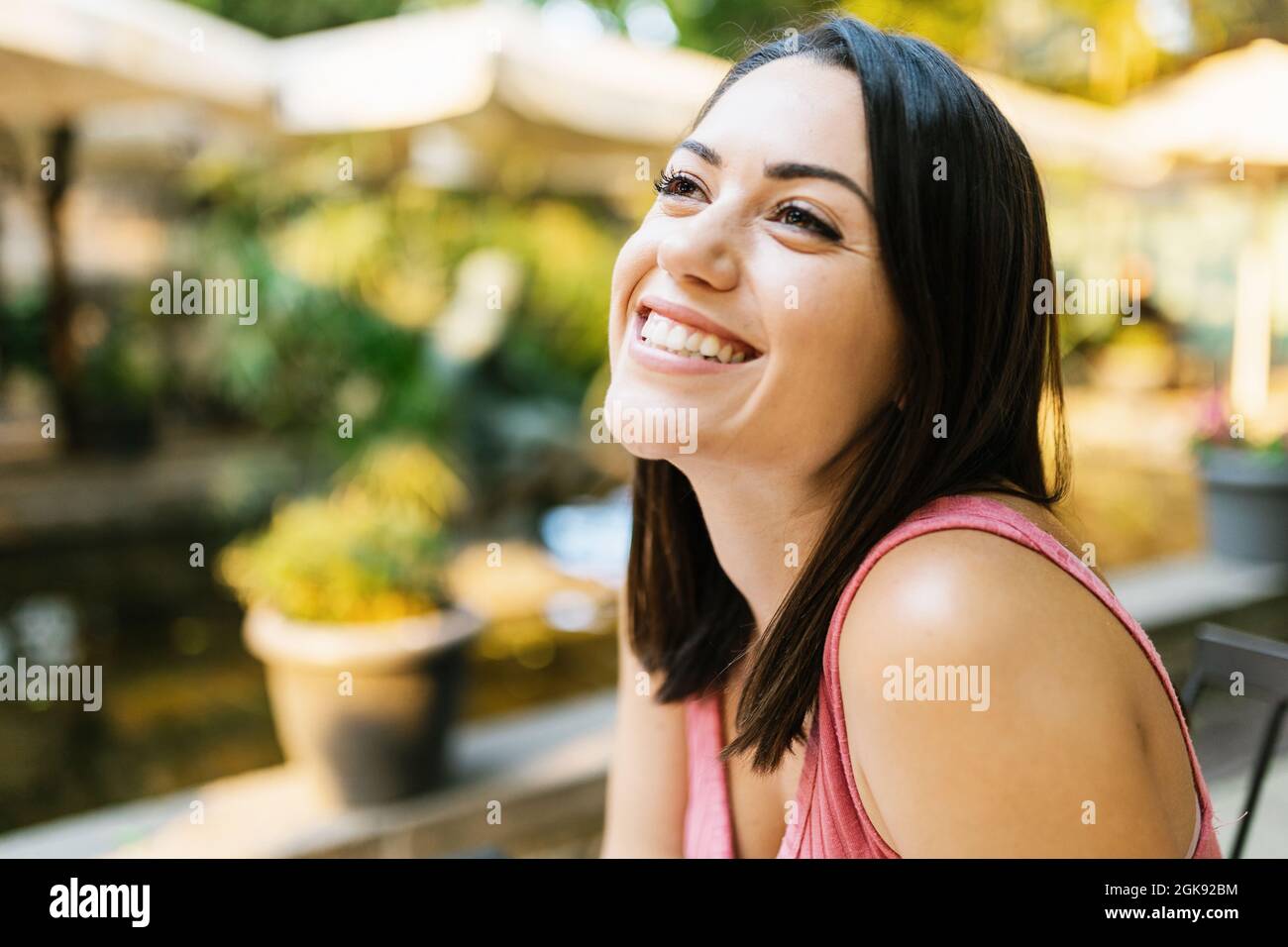 Nachdenkliche hispanische Frau, die allein im Freien sitzt Stockfoto
