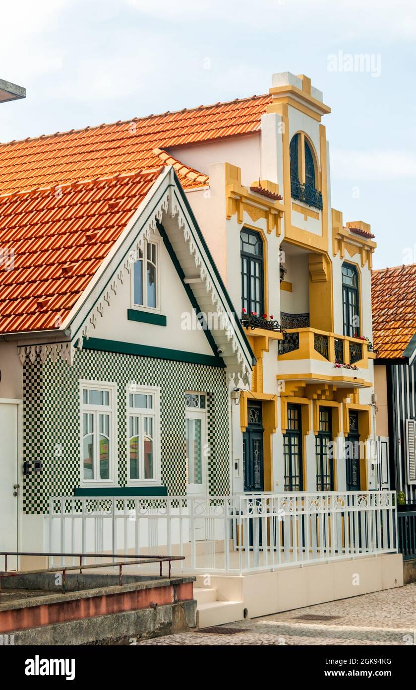 Typische Häuser in verschiedenen architektonischen bunten Stilen mit roten Dachziegeln an der berühmten Beach Costa Nova Straße in Aveiro, Portugal Stockfoto