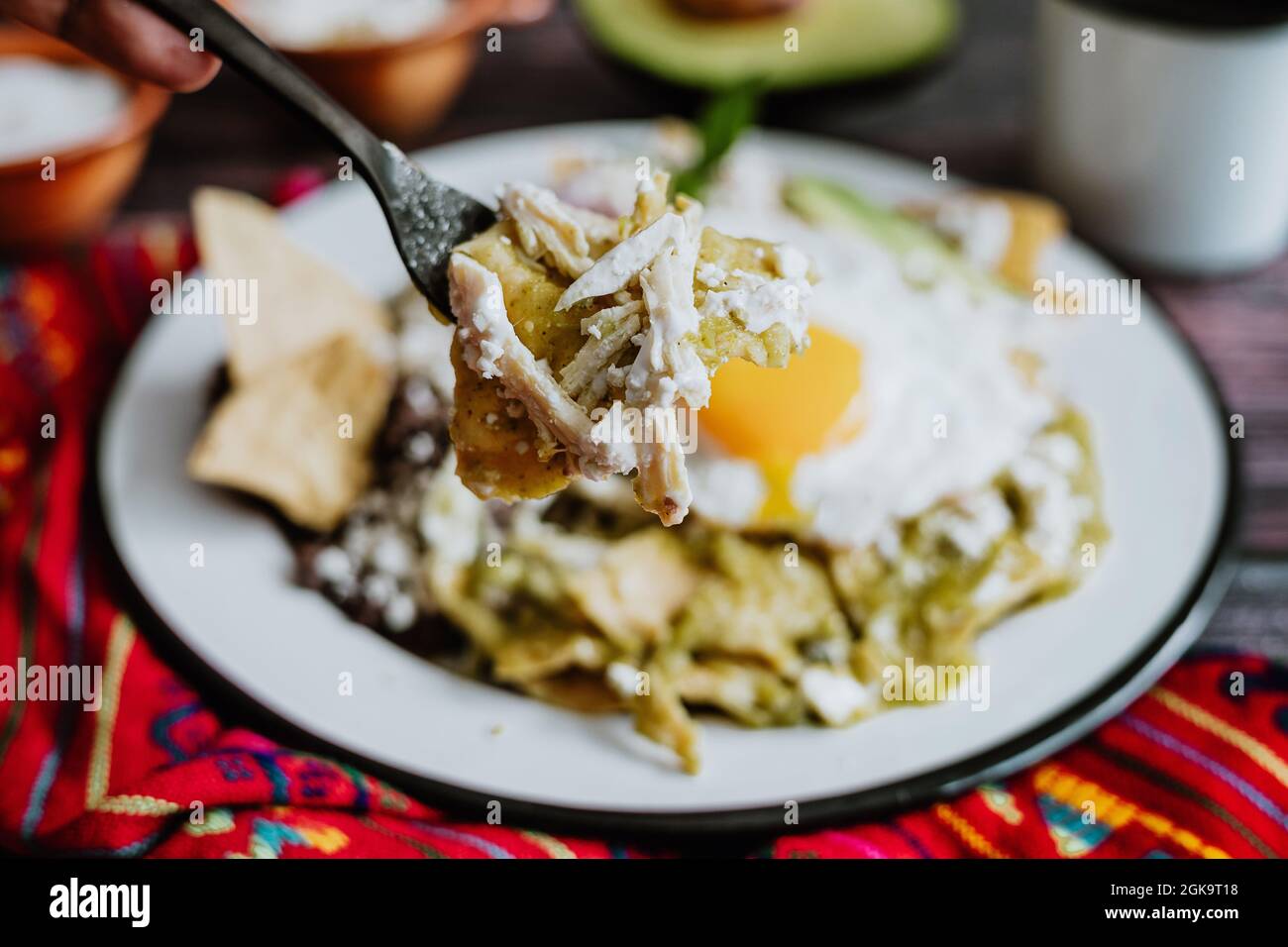 mexikanische Chilaquiles mit Spiegelei, Huhn und würziger grüner Sauce traditionelles Frühstück in Mexiko Stockfoto