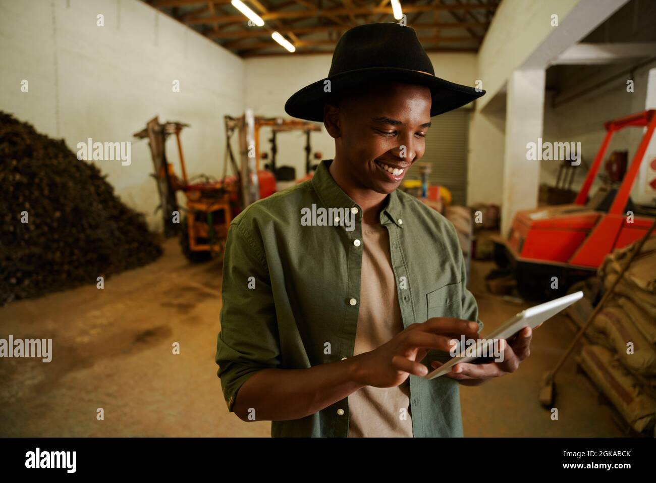 Afroamerikanischer Bauer, der im Schuppen auf einem digitalen Tablet tippt Stockfoto