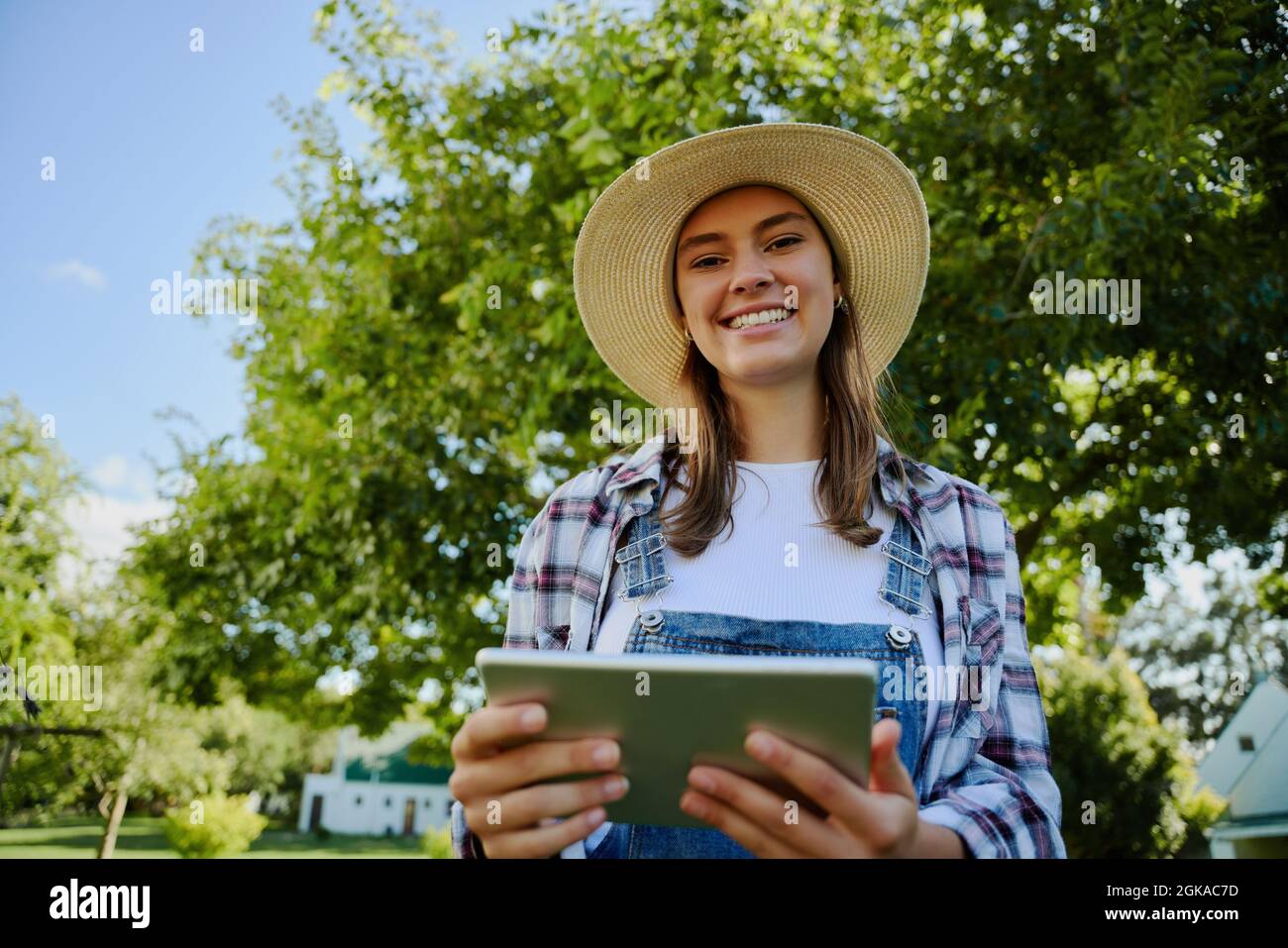 Kaukasische Farmerin, die im Freien steht und auf einem digitalen Tablet tippt Stockfoto