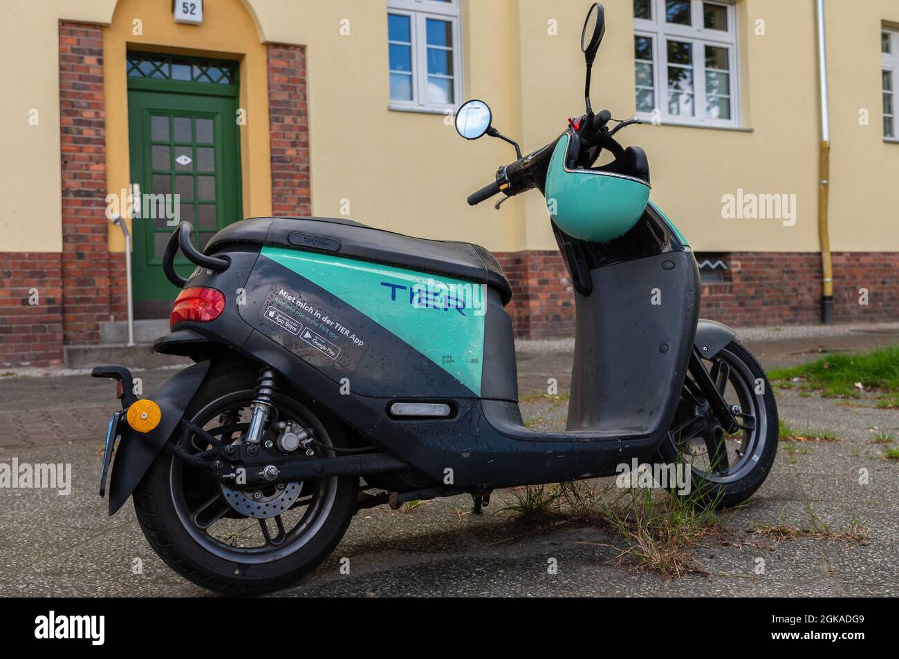 Elektroroller mit passenden Helmen, die auf dem Bürgersteig geparkt sind Stockfoto