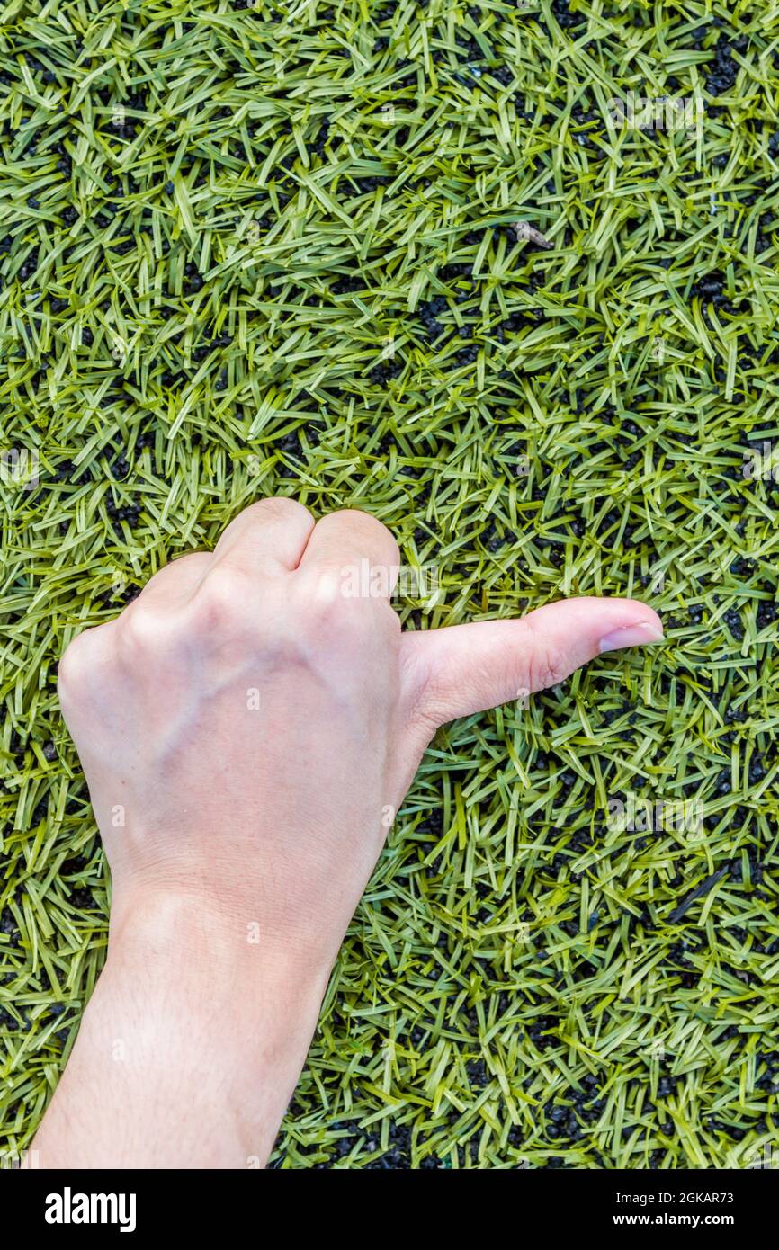 Mädchen Hand thump up auf grünem Gras Hintergrund Stockfoto