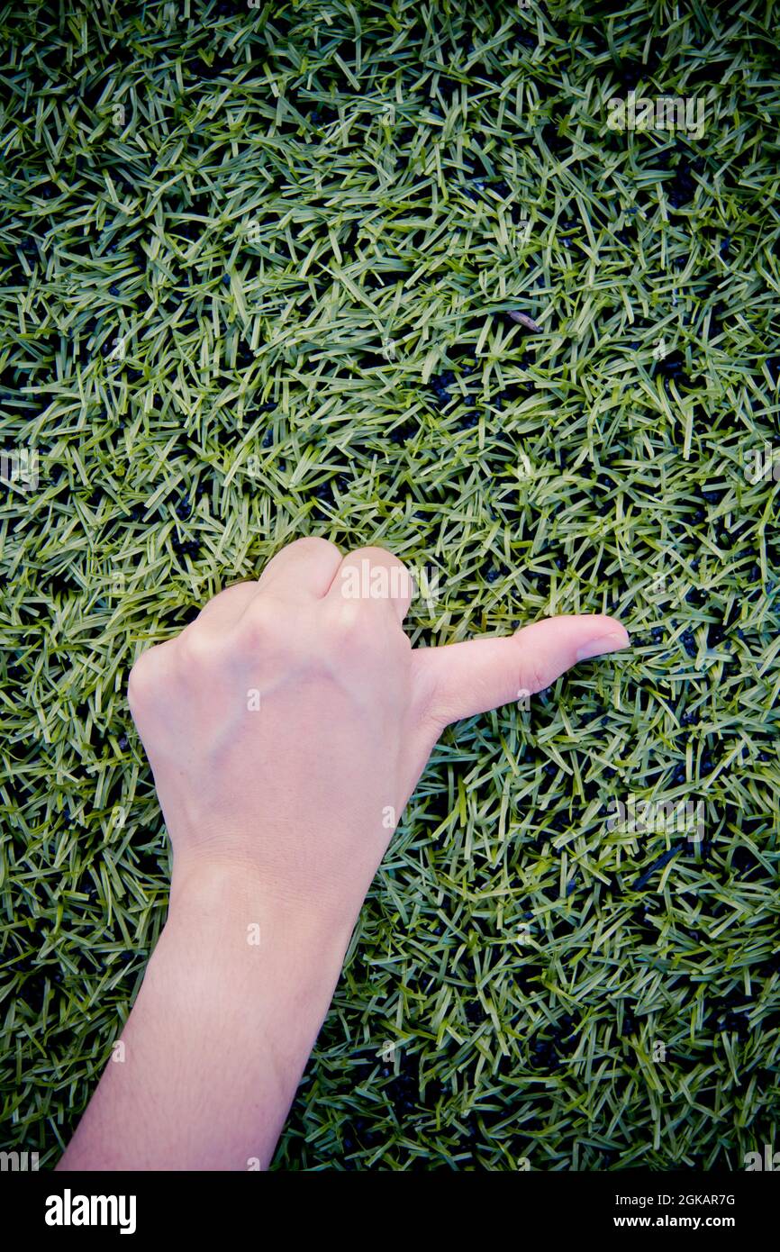 Mädchen Hand thump up auf grünem Gras Hintergrund Stockfoto