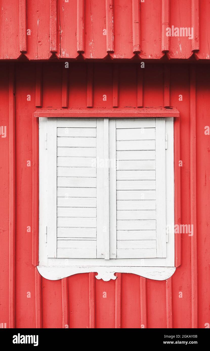 Weißer Holzverschluss an einer roten Wand. Stockfoto