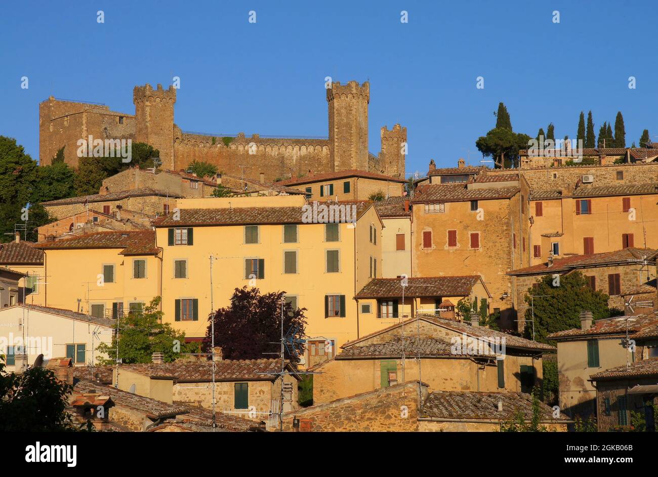 Blick auf die Hügelstadt und Türme des Schlosses kurz nach Sonnenaufgang in Montalcino, Toskana, Italien Stockfoto