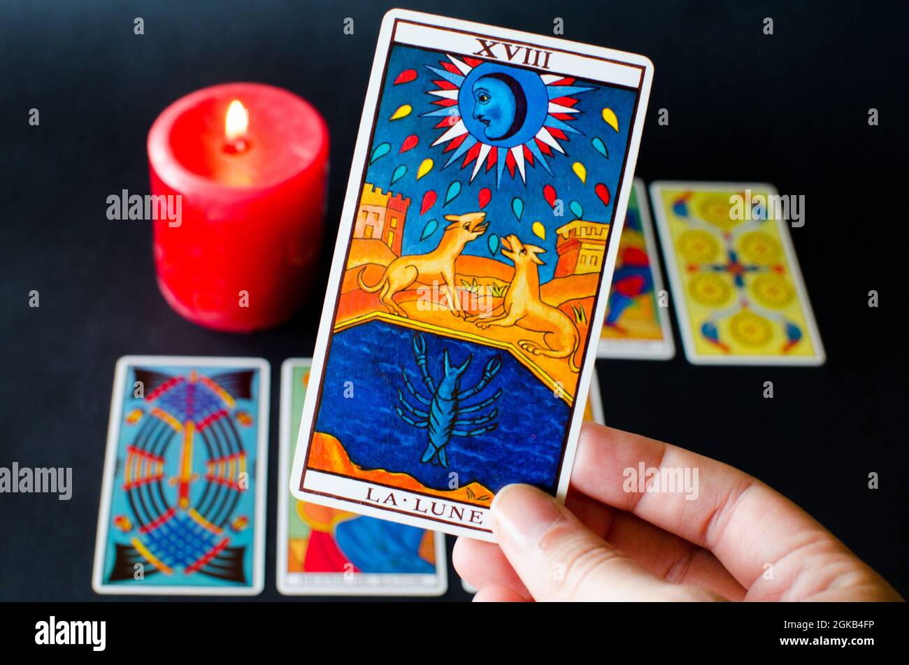 Tarot-Kartensitzung. Hand mit dem Buchstaben des Mondes Stockfoto