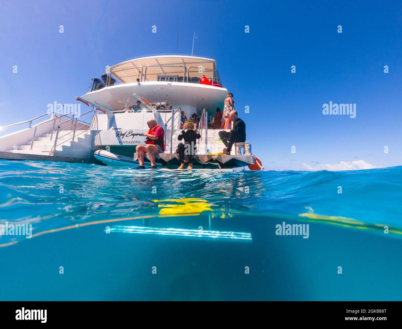 Touristen, die sich auf das Tauchen von der Rückseite eines Tauchbootes vorbereiten, Great Barrier Reef, Queensland, QLD, Australien Stockfoto