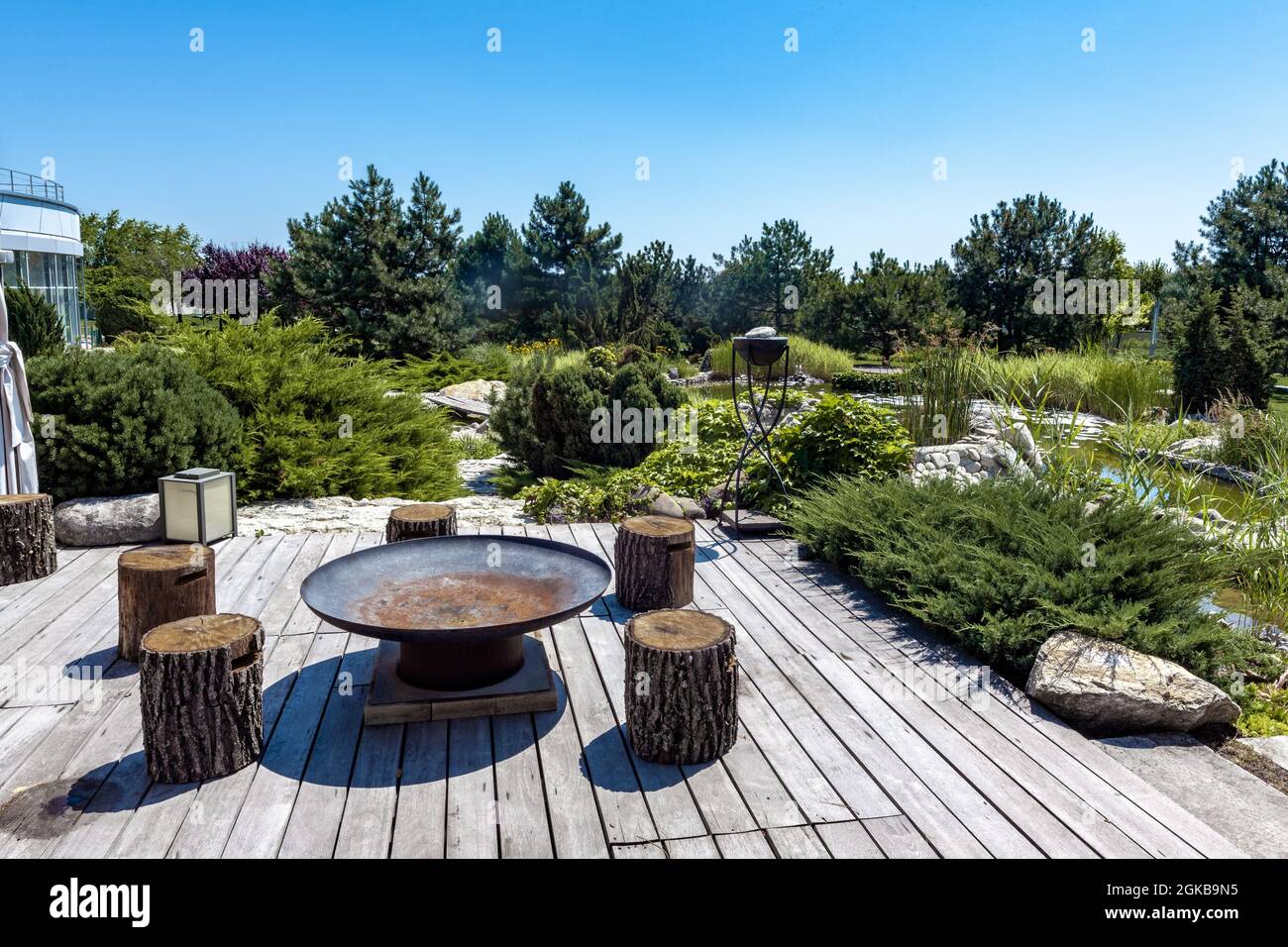 Outdoor-Sitzbereich mit Grill und Holzstümpfe im Hinterhof des Landguts im Sommer Stockfoto