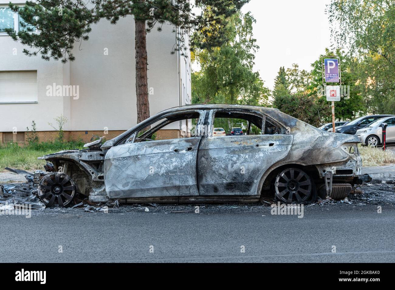 Ausgebrannte Mercedes in der Wohngegend am Straßenrand. Seitenansicht der Fahrerseite Stockfoto