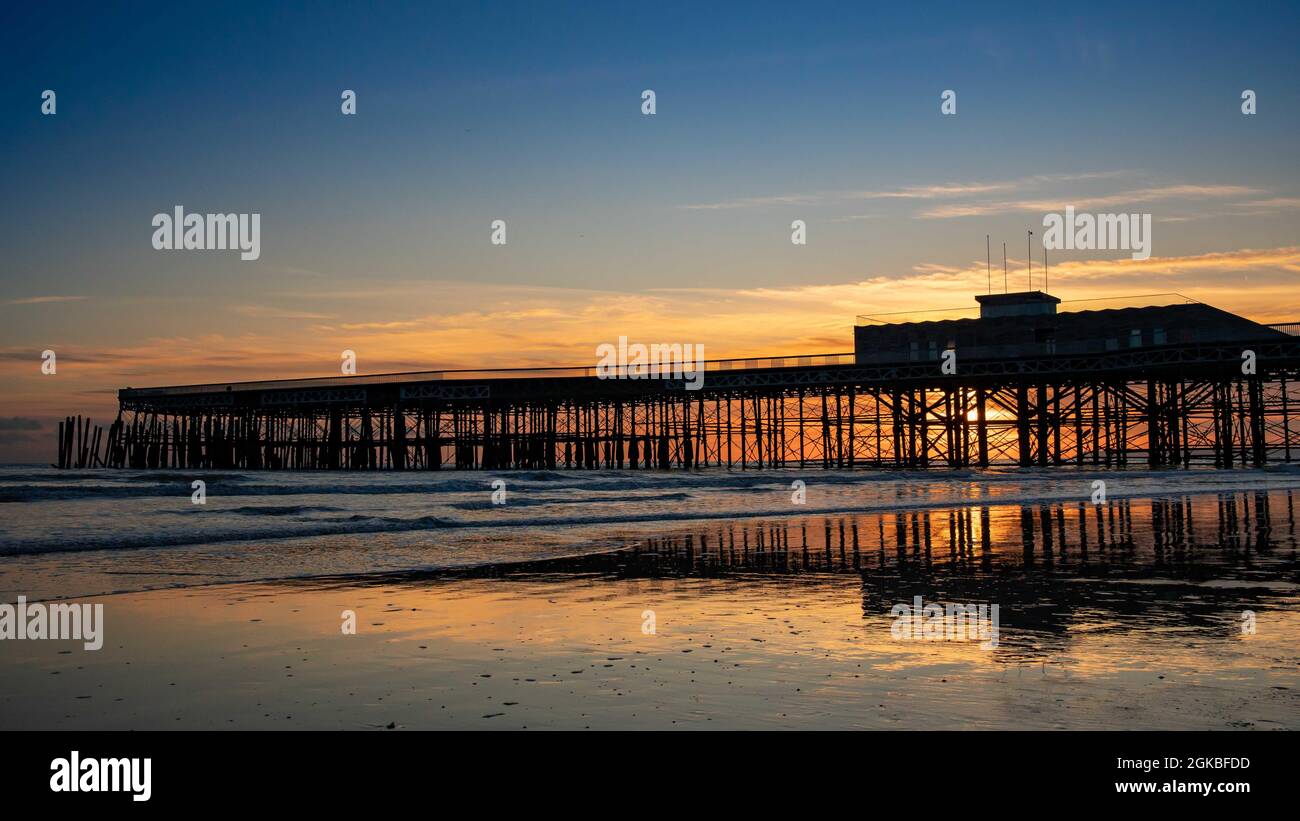 Hastings Pier & Strand bei Sonnenuntergang Stockfoto