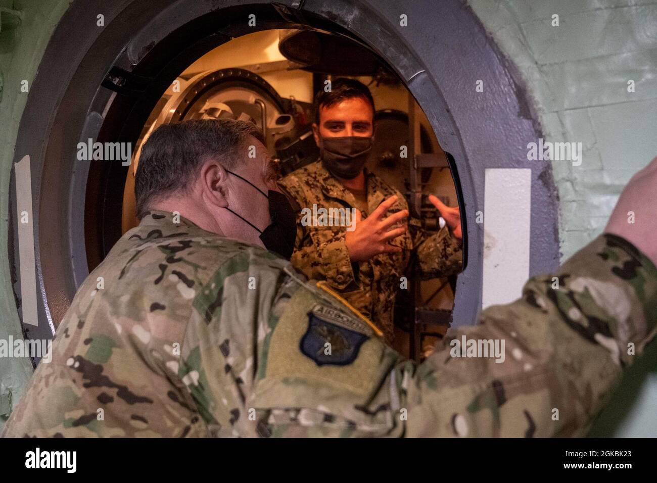 GEMEINSAME BASIS PEARL HARBOR-HICKAM, Hawaii (5. März 2021) - LT. NicholkHoffman, rechts, dem Kommandanten der U-Boot-Staffel 1 zugewiesen, zeigt den Vorsitzenden des Joint Chiefs of Staff General Mark A. Milley den Lockout-Kofferraum an Bord des Schnellangriffs-U-Bootes USS North Carolina der Virginia-Klasse (SSN 777). Milley besichtigte das U-Boot und engagierte sich bei seinem Besuch bei der Joint Base Pearl Harbor-Hickam mit Matrosen. Stockfoto