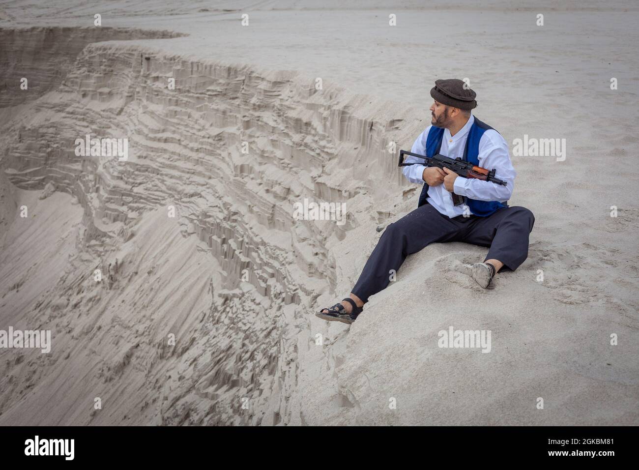 Ein Soldat der Taliban überwacht eine Straße in Afghanistan. Ein Soldat steht mit einer Waffe auf der Wache, um zu töten. Stockfoto