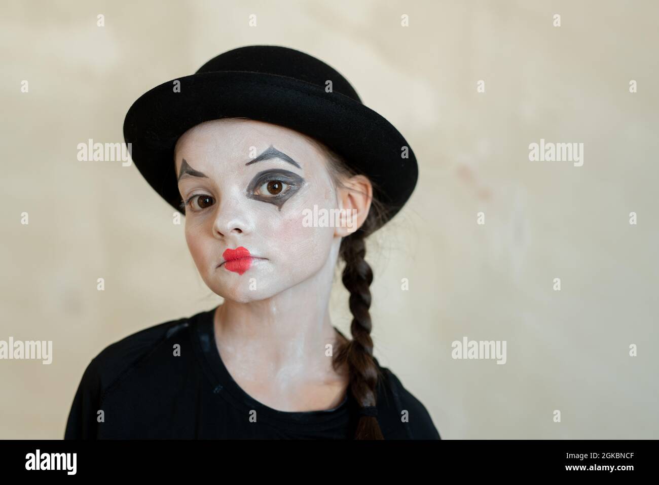 Niedliches ernstes Mädchen mit halloween Make-up, das dich vor weißem Hintergrund ansieht Stockfoto