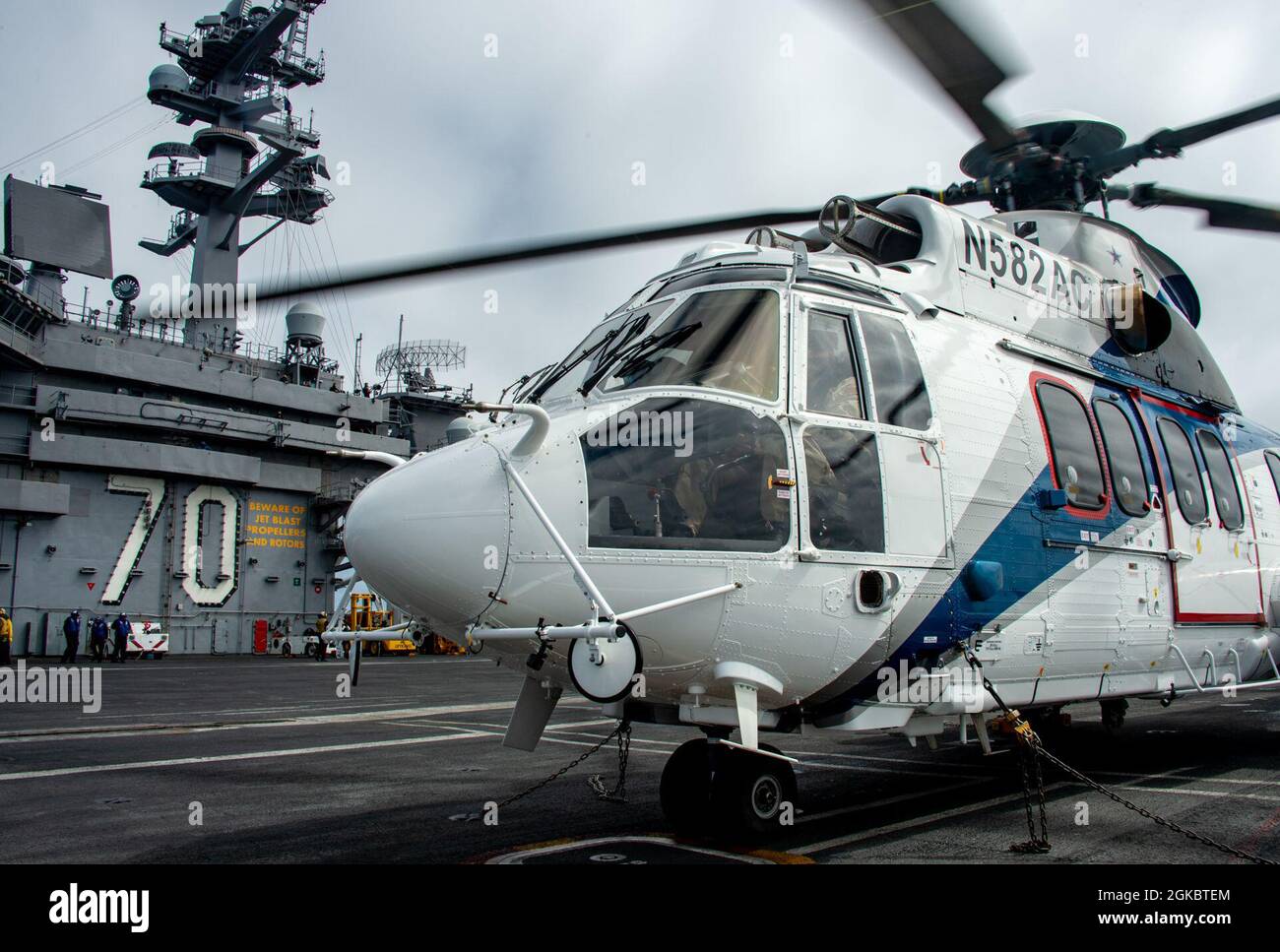 210306-N-LU761-1811 PAZIFISCHER OZEAN (MÄRZ 6, 2021) Ein ziviler H225 Super Puma bereitet sich während der Transporte auf den Start eines nachgestellten Motorstrommoduls des Typs F135 vom Nimitz-Klasse-Nuklearflugzeugträger USS Carl Vinson (CVN 70) zum Trockenfrachtschiff USNS Richard E. Byrd (T-AKE 4) in der Lewis- und Clark-Klasse während eines vertikalen Wiederauffüllens auf See (VERTREP) vor. Diese Übung war der erste Flugzeugträger VERTREP eines imitierten Motorleistungsmoduls F135, das als Grundlage für den Einzelmotor des F-35C Lightning II dient, den einzigen einmotorigen Festflügeljet an Bord von Vinson und den neuesten im Joint Strike Fighter Stockfoto