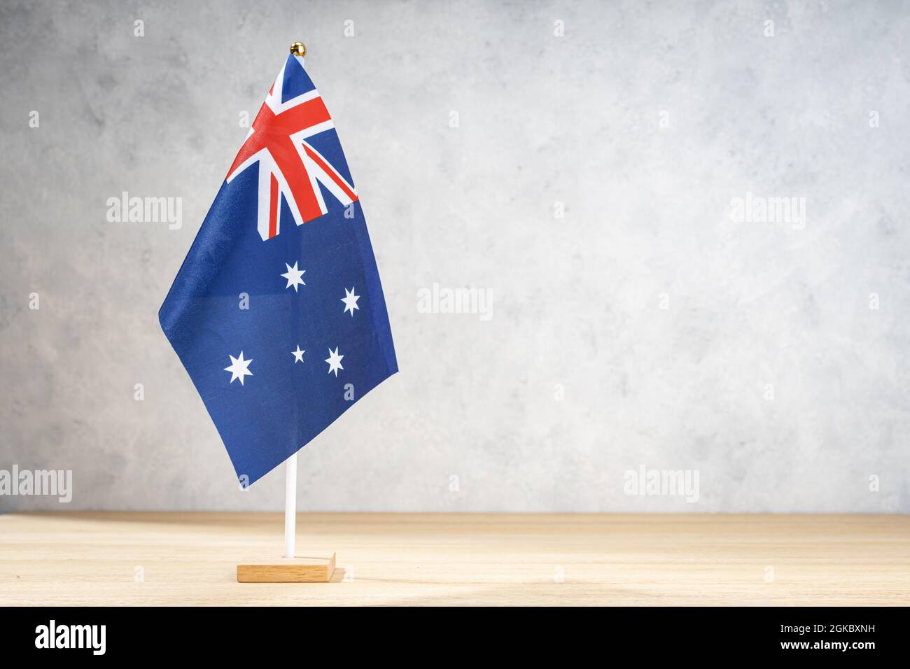Australische Tischflagge auf weißer strukturierter Wand. Platz für Text, Entwürfe oder Zeichnungen kopieren Stockfoto