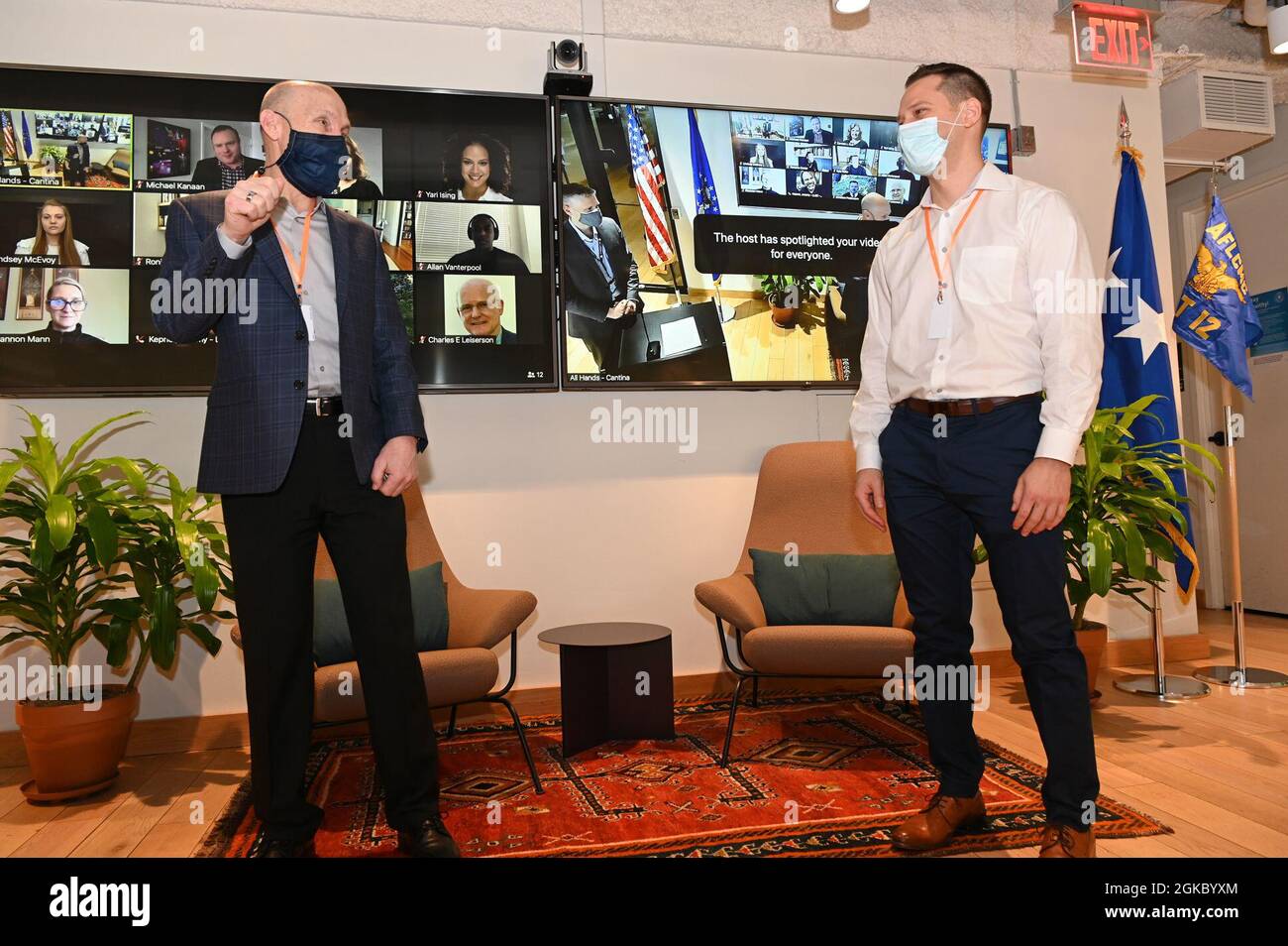 Air Force Vice Chief of Staff General David W. Allvin, links, überreicht Capt. Kyle McAlpin, Massachusetts Institute of Technology, Forschungsflugkommandant für Künstliche Intelligenz, während einer Tour der Air Force Life Cycle Management Center Detachment 12, Kessel Run, am Hauptsitz in Boston, März 8. Stockfoto