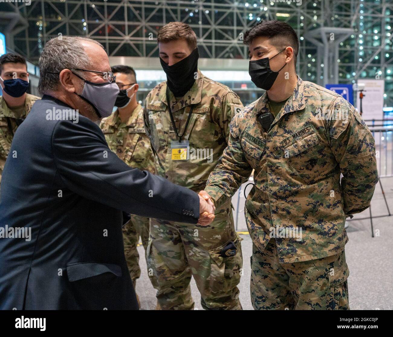Steven A. Castleton, ziviler Berater des Sekretärs der Armee New York (Süd), und James Hendon, Kommissar des New Yorker Dienstministeriums für Veteranen, Besuchen Sie die Dienstmitglieder und die staatlichen Partner zur nächtlichen Schicht zur Unterstützung der staatlichen Bemühungen zur Bereitstellung von Massen-COVID-19-Impfungen, die vom New Yorker Gesundheitsministerium im Javits Convention Center in Manhattan, New York, am 08. März 2021 durchgeführt werden. Castleton stellte dem New York Naval Marine CPL eine Challenge-Münze vor. Jose Cristales, dem Northern Command zugewiesen, und zivile Staatspartner, zu Ehren ihrer SE Stockfoto
