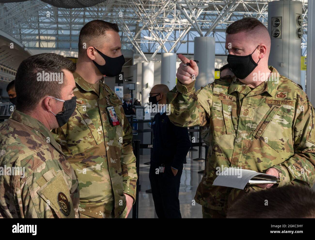 Chief Master Sgt. Chad Bickley (rechts), Kommandochef der 18. Luftwaffe, diskutiert die Check-in-Prozesse mit Master Sgts. Daniel Borowski, Leiter der 305. Aerial Port Squadron Detachment 1, und Gilberto Soto, Leiter der 305. APS-Detachment 1, am Patriot Express COVID-19 Testgelände am Baltimore/Washington International Thurgood Marshall Airport in Baltimore, Maryland, 9. März 2021. Patriot Express-Flüge werden von kommerziellen Fluggesellschaften durchgeführt, die vom Verteidigungsministerium beauftragt wurden. Das Team der Patriot Express COVID-19-Testeinrichtung sorgt für die Gesundheit und Sicherheit der Servicemitarbeiter und der Tei Stockfoto