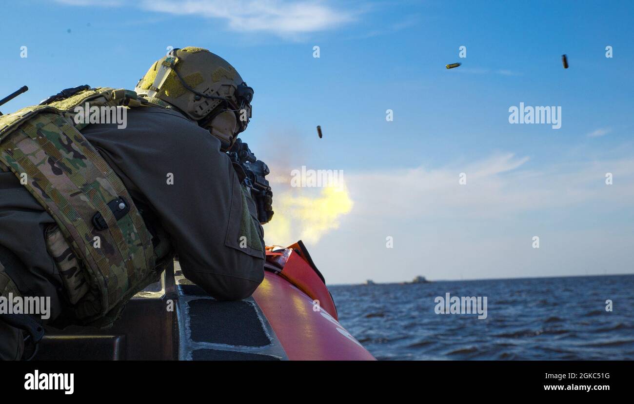 Ein U.S. Coast Guardsman mit einem Maritime Security Response Team (MSRT) feuert während eines fortgeschrittenen Trainings zum Verbot von Maschinengewehr-Booten in der Nähe von Bombing Target 9, North Carolina, 9. März 2021 auf Ziele über dem Wasser. Die Mission von MSRT ist es, die Reaktion auf die Bedrohung durch den Seeverkehr als Primärtruppe oder als Teil eines Pakets von adaptiven Kräften der US-Küstenwache oder der interagenturischen Streitkräfte durchzuführen. Die Ausbildungsstätten des Marine Corps Air Station Cherry Point, North Carolina, wie BT-11 und BT-9 ermöglichen es Streitkräften aus dem gesamten Verteidigungsministerium und dem Heimatschutzministerium, eine breite Art und Weise zu handeln Stockfoto