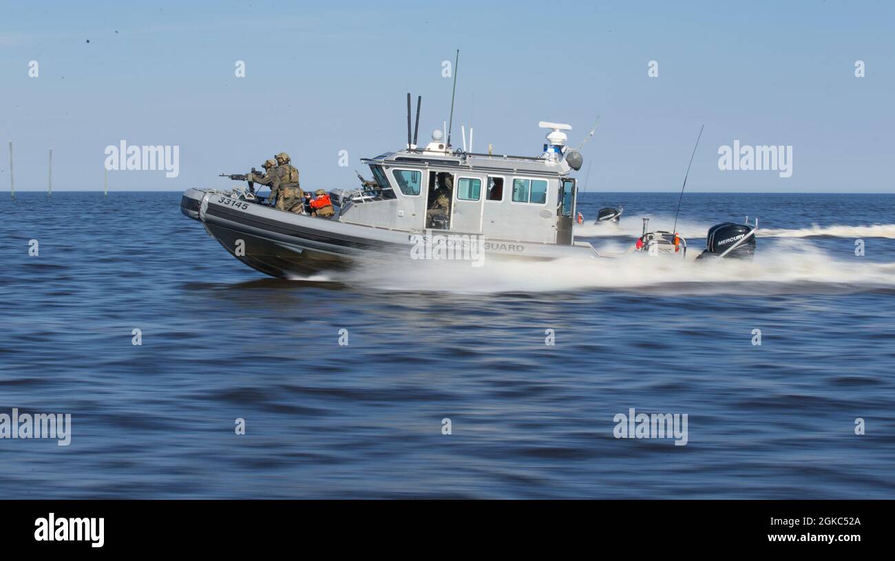 U.S. Coast Guardsmen mit einem Maritime Security Response Team (MSRT) feuern ein M240B-Maschinengewehr von einem Einsatzboot während eines fortgeschrittenen Interdiktionstrainings in der Nähe von Bombing Target 9, North Carolina, 9. März 2021. Die Mission von MSRT ist es, die Reaktion auf die Bedrohung durch den Seeverkehr als Primärtruppe oder als Teil eines Pakets von adaptiven Kräften der US-Küstenwache oder der interagenturischen Streitkräfte durchzuführen. Die Ausbildungsstätten des Marine Corps Air Station Cherry Point, North Carolina, wie BT-11 und BT-9, ermöglichen es Streitkräften aus dem gesamten Verteidigungsministerium und dem Heimatschutzministerium, eine Vielzahl von Schulungsveranstaltungen durchzuführen Stockfoto