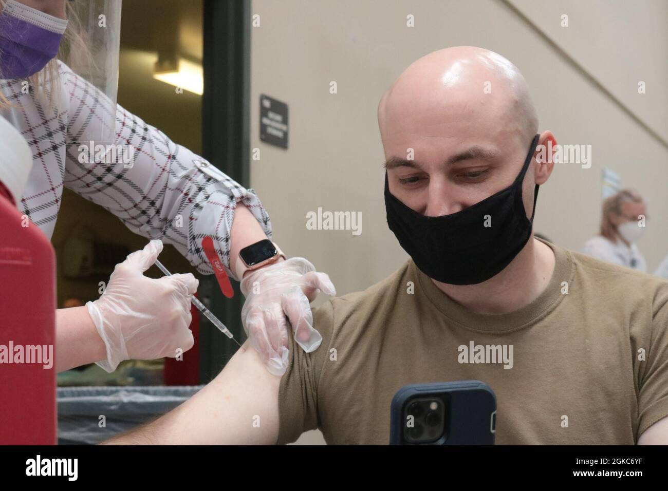 Ein Arzt verabreicht den Jannsen COVID-19-Impfstoff an das Personal Sgt. Godot Galgano, nicht beauftragter Beamter für öffentliche Angelegenheiten, 1. Theater Sustainment Command, am Fort Knox, Kentucky, Impfstelle am 10. März 2021. „Ich denke, wenn Sie der Wissenschaft vertrauen und darauf vertrauen, wie Ihr Körper damit umgehen wird, sollten Sie wahrscheinlich den Impfstoff erhalten, weil er Ihnen und Ihren Lieben helfen wird, vor den Auswirkungen des Virus zu schützen, die es gibt“, sagte Galgano. Stockfoto