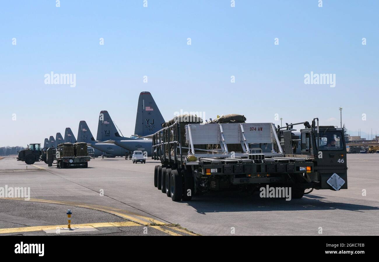 Ein K Loader fährt über die Fluglinie, bevor die Pakete des Containers-Liefersystems der Japan Ground Self-Defense Force auf einen C-130J Super Hercules hochgeladen werden, der dem 374. Luftlift-Flügel auf der Yokota Air Base, Japan, zugewiesen wurde, 10. März 2021. Airborne 21 war der größte US-japanische Lufteinsatz in der Geschichte, an dem etwa 500 JGSDF-Fallschirmjäger, 12 C-130s und 134 CDS beteiligt waren. Stockfoto