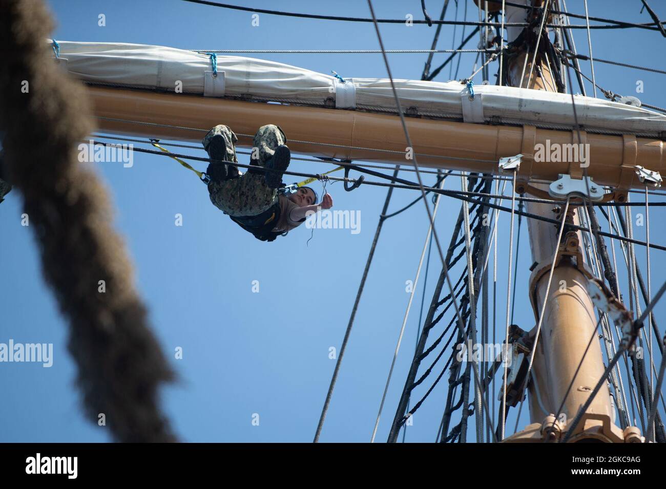 ATLANTISCHER OZEAN (10. März 2021) der US-Navy-Airman Megan Kearns klettert auf dem Vorwärtsbahnhof an Bord von USCGS Eagle (WJX 327), während er im Atlantischen Ozean unterwegs ist. Matrosen, die der USS Constitution zugewiesen wurden, sind mit Eagle unterwegs, um in der Segelkunst geschult zu werden und die Beziehungen zwischen Marine und Küstenwache weiter auszubauen. Stockfoto