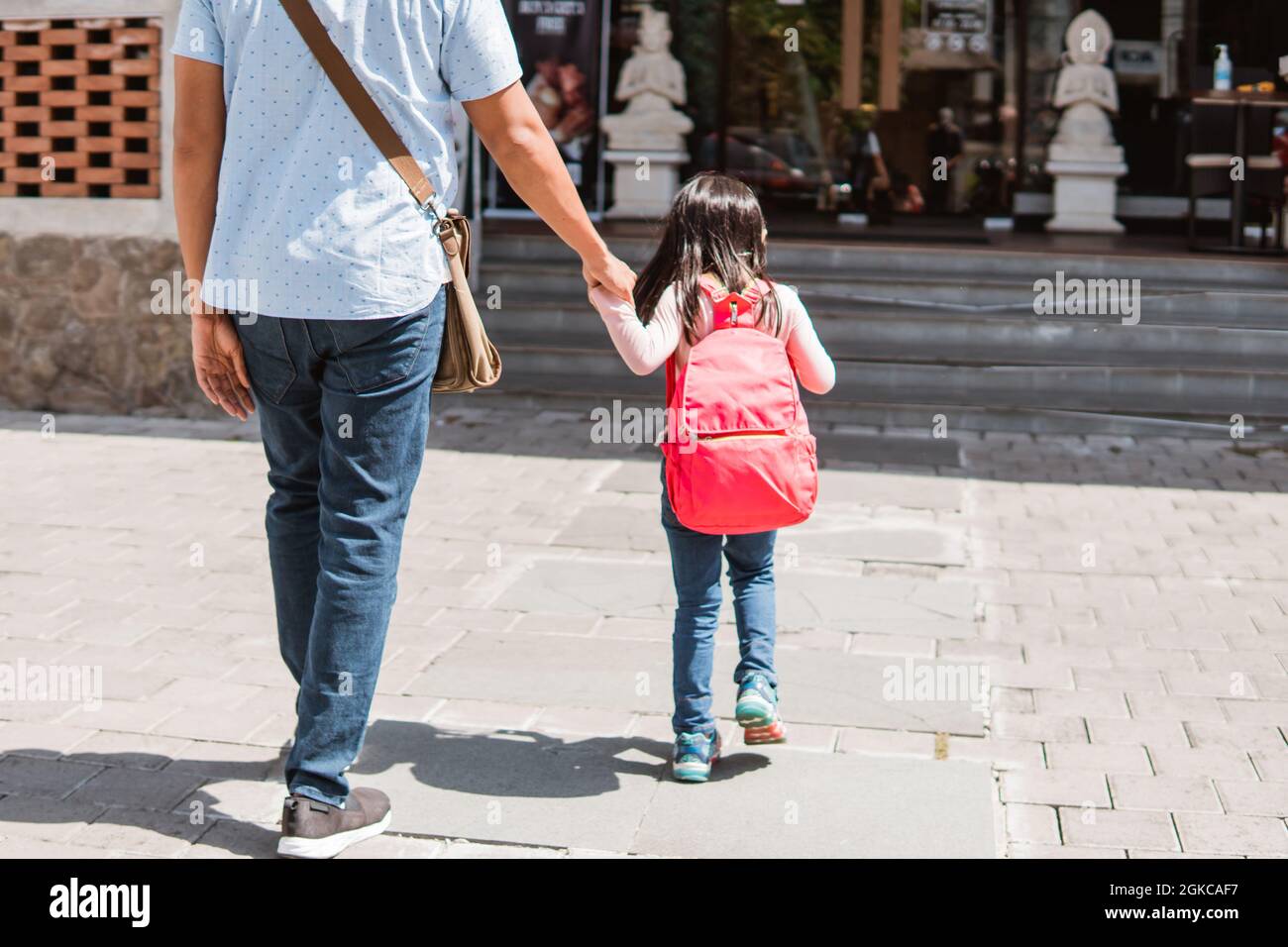 Vater geht mit seiner Tochter zur Schule Stockfoto