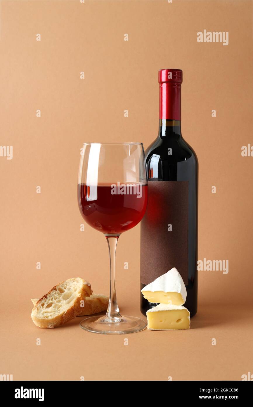 Flasche und Glas Wein, Käse und Brot auf beigem Hintergrund Stockfotografie  - Alamy