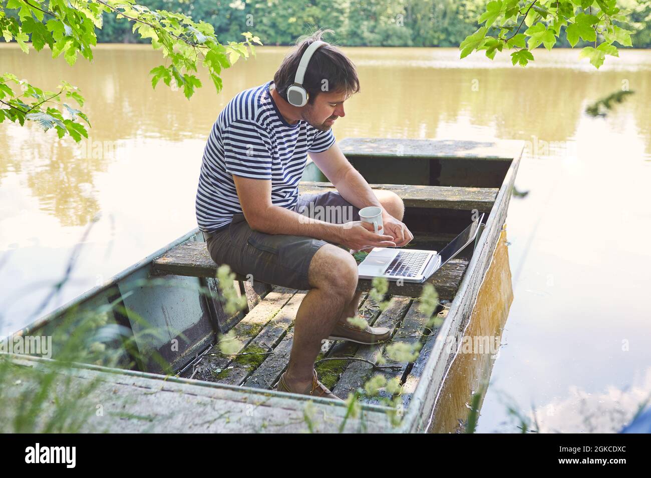 Freiberuflicher Mann Mit Laptop-Computer Während Der Videokonferenz Am See In Den Sommerferien Stockfoto