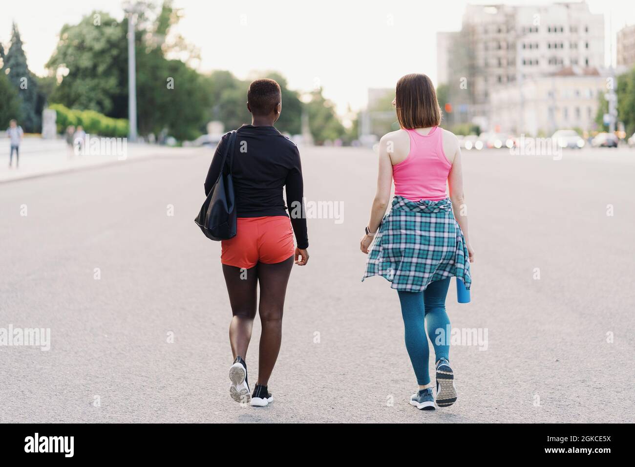 Freunde Rückansicht in Sportswear Wandern nach einer Sportveranstaltung in der Stadt diskutieren. Multiethnische Frauen mit einem Fitness-Workout Joggen. Stockfoto