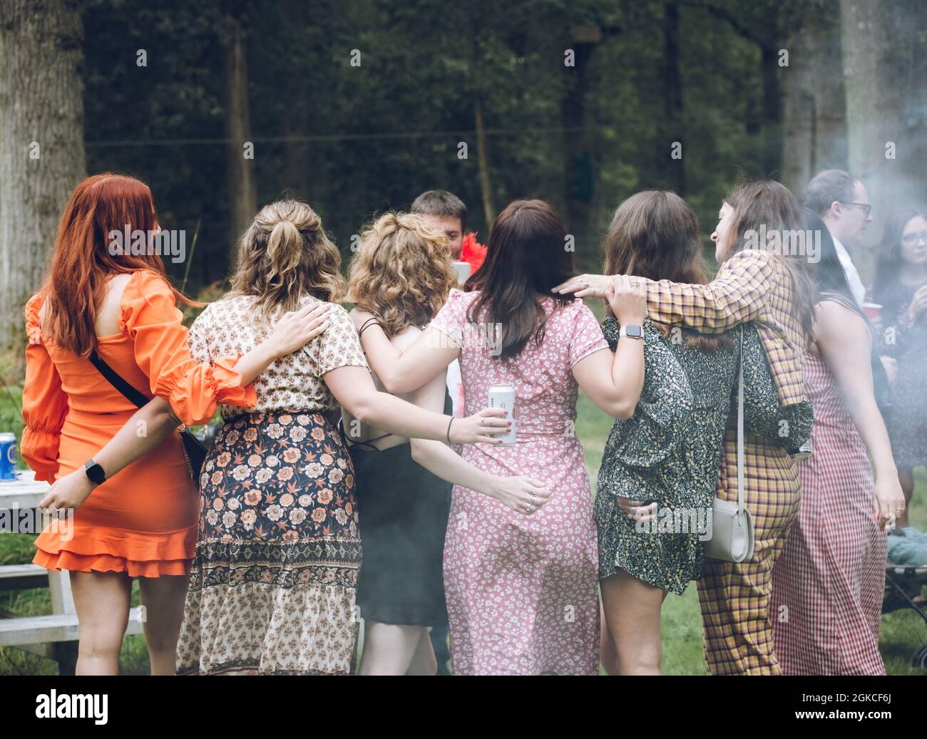 Eine Gruppe von Freundinnen umarmt sich, während sie bei einer Veranstaltung im Freien Musik hören Stockfoto