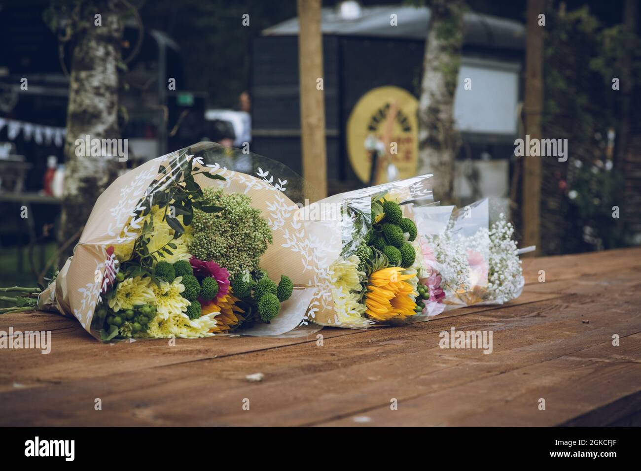 Blumensträuße, die auf einen Holztisch gelegt sind Stockfoto