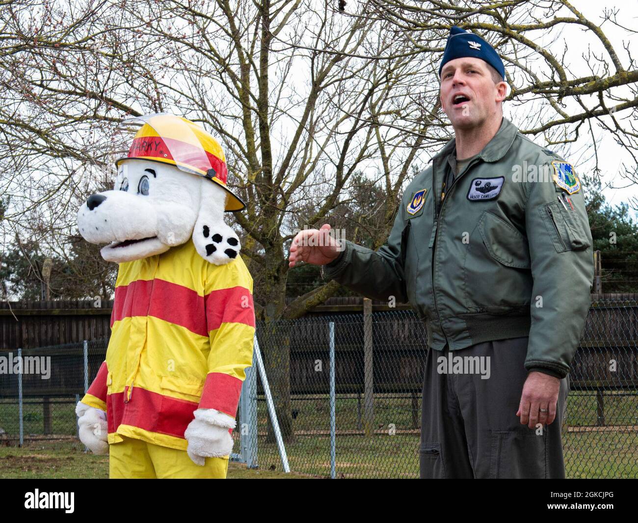 Col. Jason Camilletti, Kommandant des 48th Fighter Wing, spricht bei einer Zeremonie zum Schneiden von Bändern für den Hundepark Liberty Paws neben Sparky the Firedog, Maskottchen der 48th Fighter Wing Fire Department, in der Royal Air Force Lakenheath, England, am 13. März 2021. Vom Konzept bis zur Realität dauerte das Hundepark-Projekt Liberty Paws nur knapp fünf Monate und beinhaltet einen Agility-Kurs für Hunde aller Größen. Stockfoto