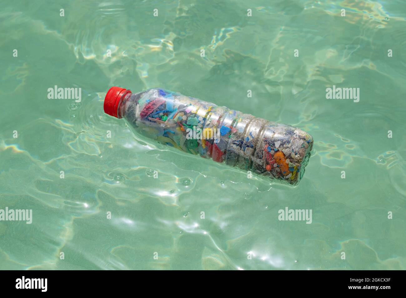 Flasche gefüllt mit Mikroplastik, die auf dem Meerwasser liegt  Stockfotografie - Alamy