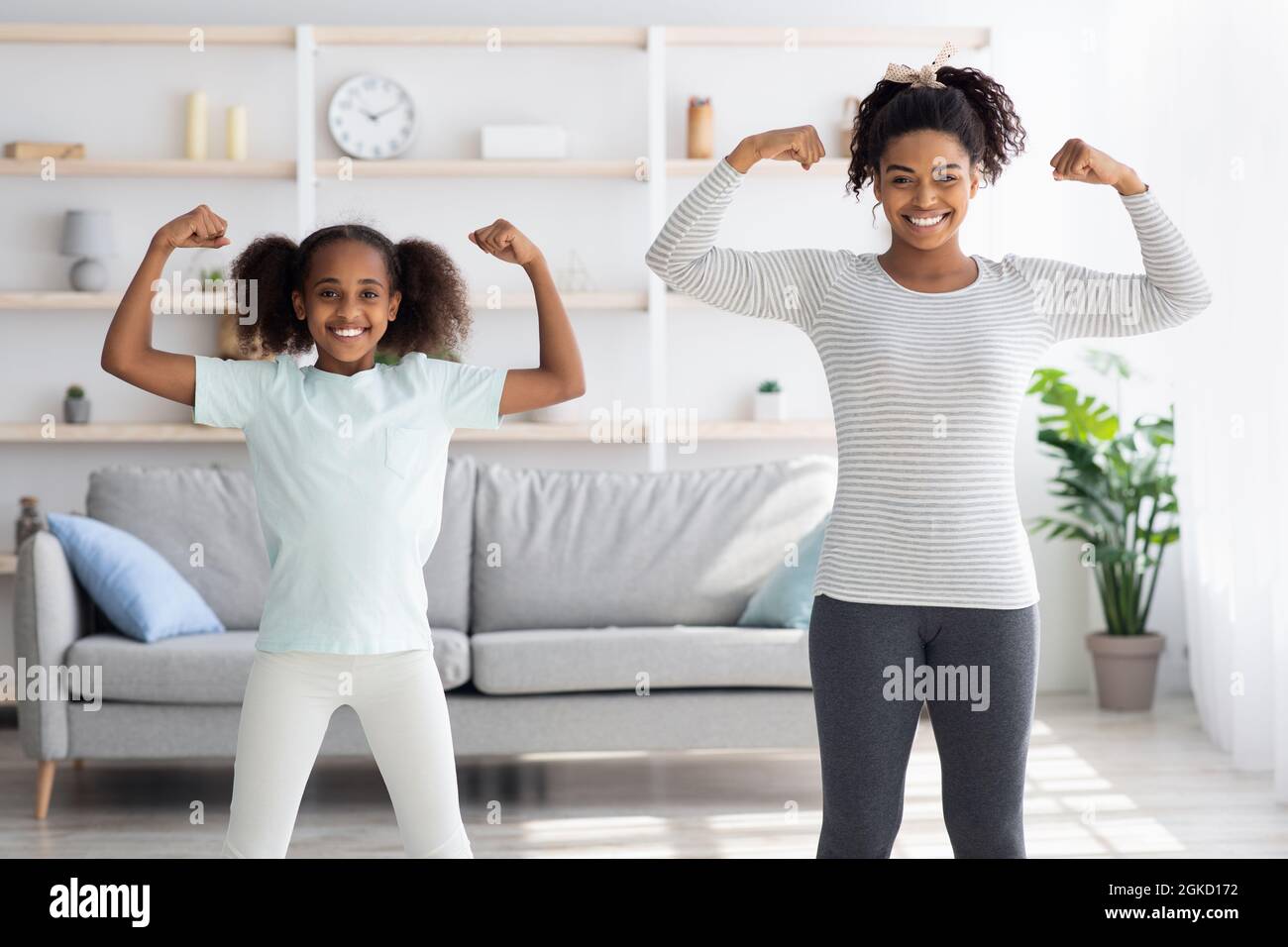 Starke afroamerikanische Mutter und Tochter zeigen ihre Muskeln Stockfoto