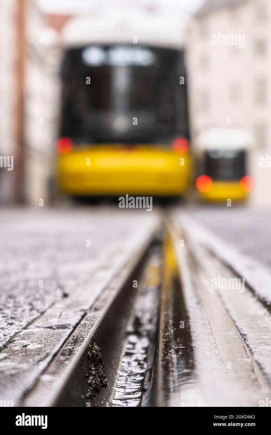 Zwei Straßenbahnen in der Unschärfe an der Endstation mit Fokus auf der vorderen Schiene Stockfoto