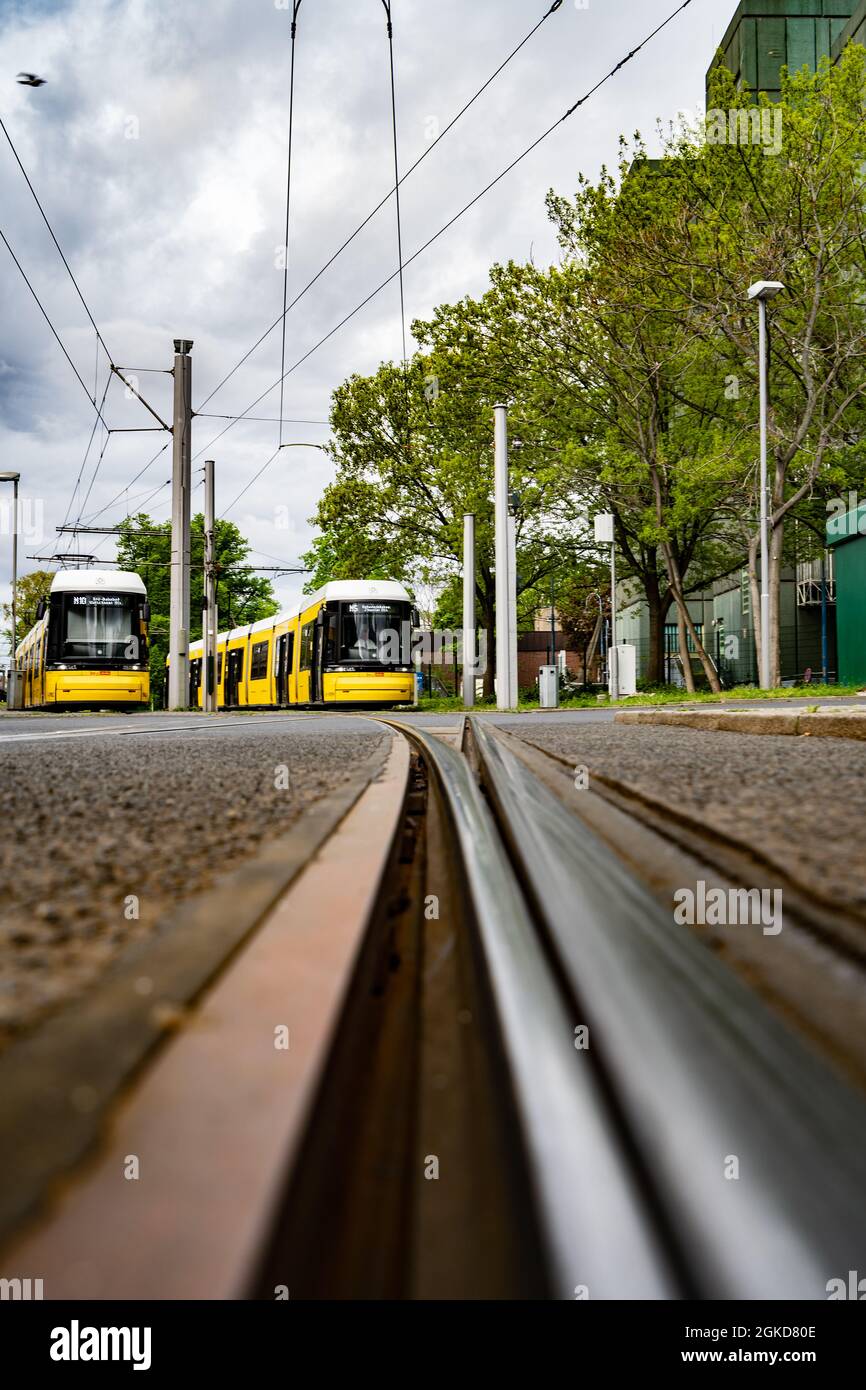 Zwei Straßenbahnen in der Unschärfe an der Endstation mit Fokus auf der vorderen Schiene Stockfoto