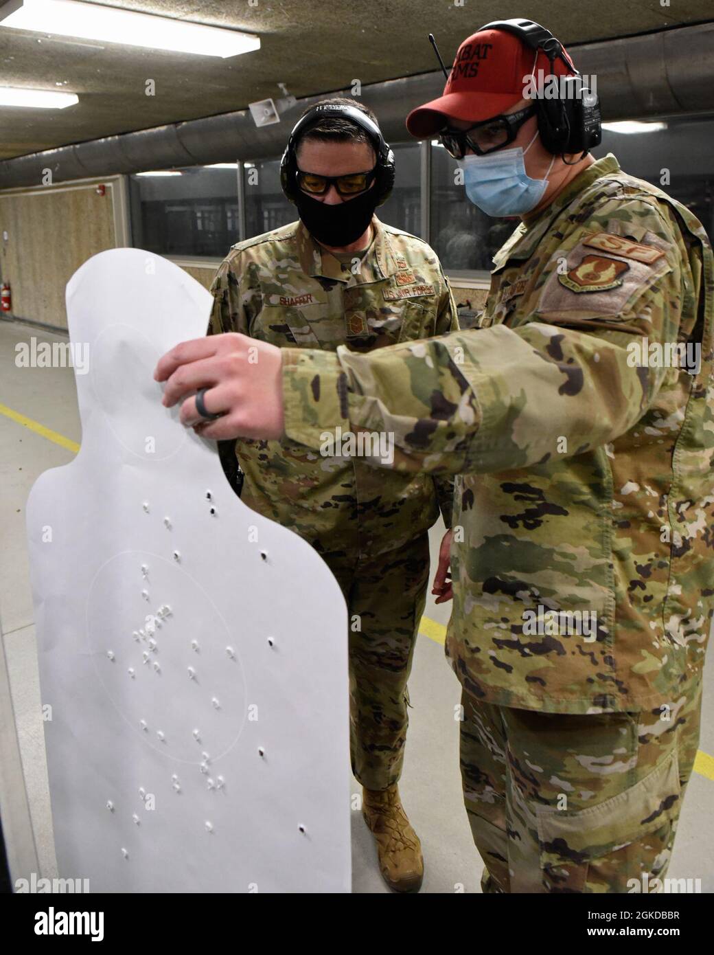 US Air Force Chief Master Sgt. Jason Shaffer, Kommandochef des 88. Luftwaffenflügels, hört sich den Senior Airman Jacob Kubek an, den Instruktor für die 88. Sicherheitsschwadron-Kampfwaffen, als er am 19. März 2021 die Qualifikation des Chefs mit der M18-Pistole auf der Wright-Patterson Air Force Base, Ohio, überprüft. Kampfwaffenausbilder arbeiten daran, das Personal der 88 ABW-Waffen für Bereitschafts- und Einsatzanforderungen qualifiziert zu halten. Stockfoto